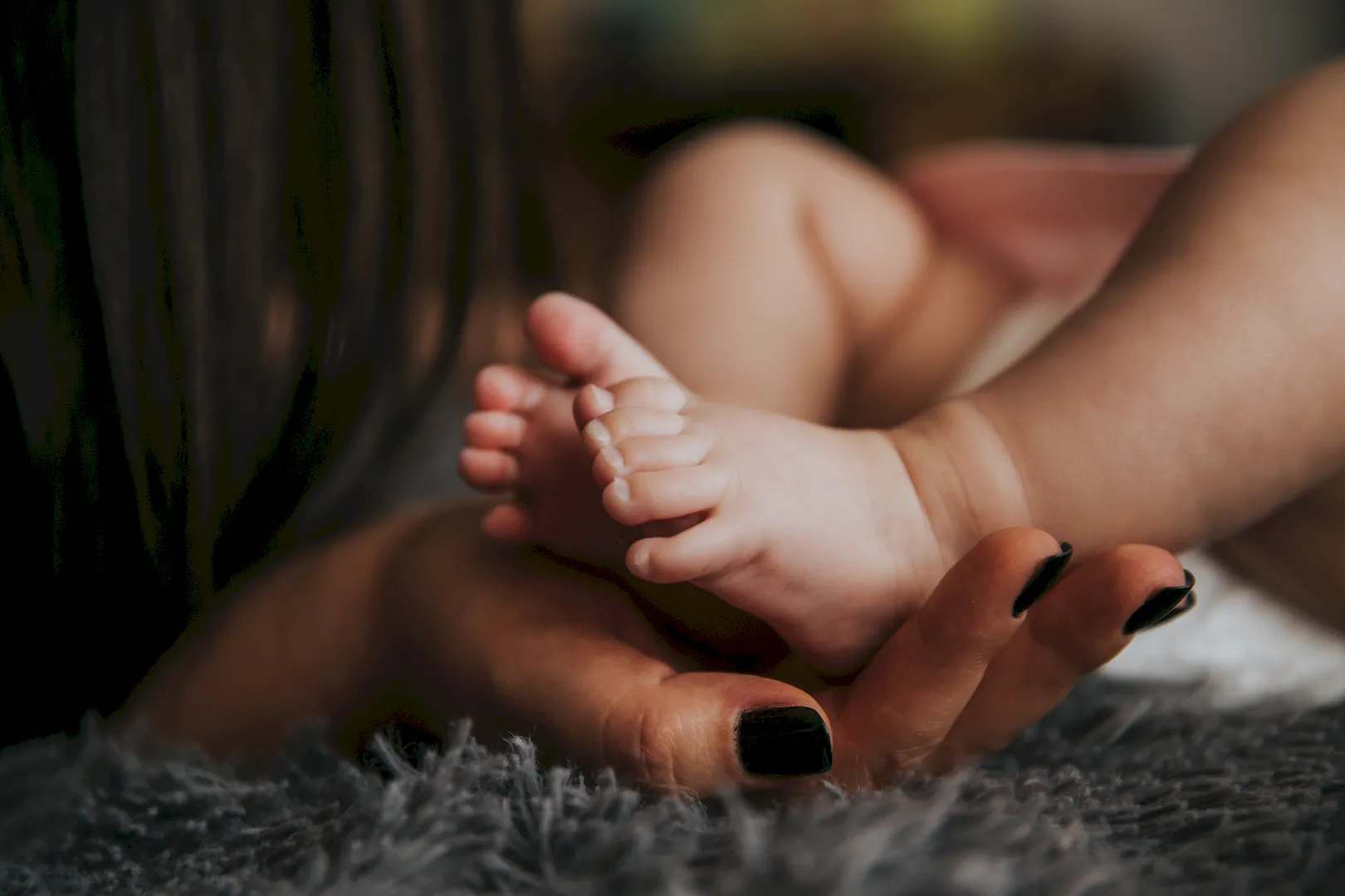 Mother gently holding her child's leg — official Anuvansh Clinic photograph